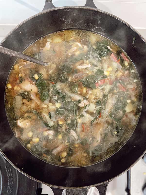 Chicken, ginger and corn nourishing soup cooking on the stove