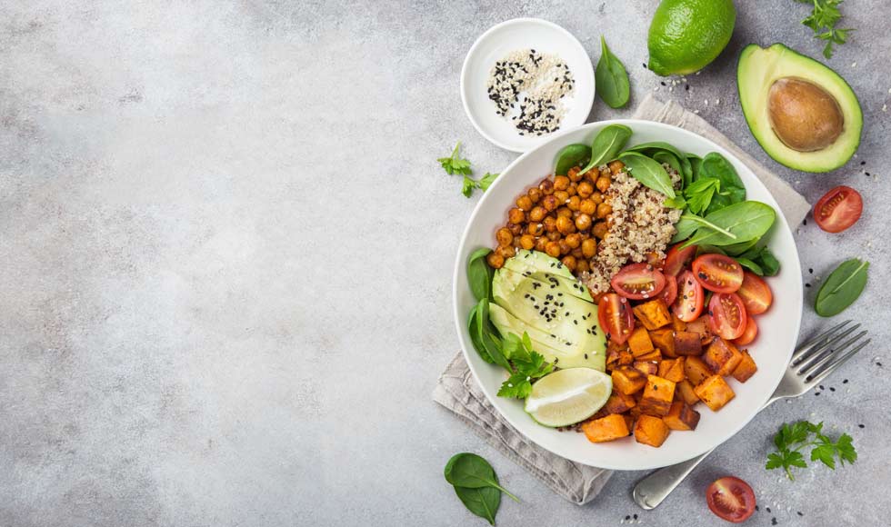 Healhty vegan lunch bowl. Avocado, quinoa, sweet potato, tomato, spinach and chickpeas vegetables salad