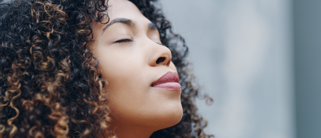 Woman looking to the sky contentedly with eyes closed